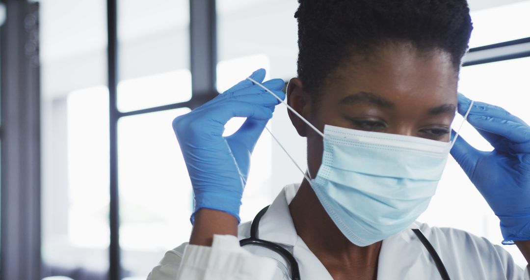 African american female doctor wearing surgical mask and gloves