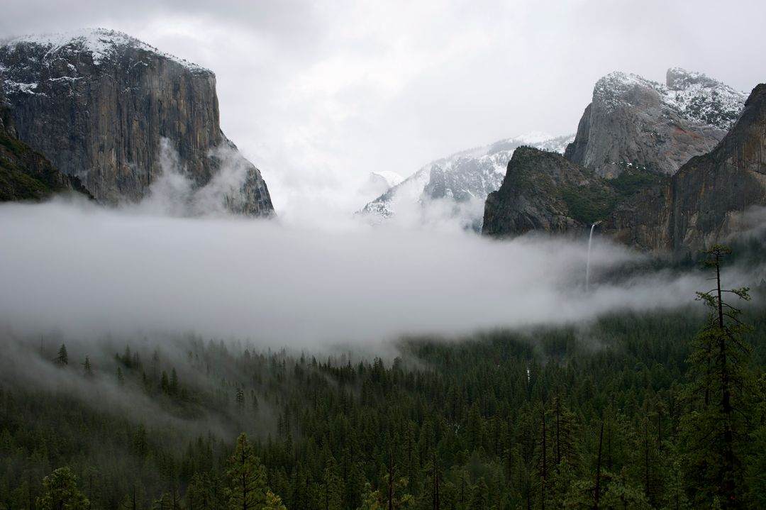 Majestic Foggy Valley Surrounded by Mountain Peaks - Free Images, Stock Photos and Pictures on Pikwizard.com