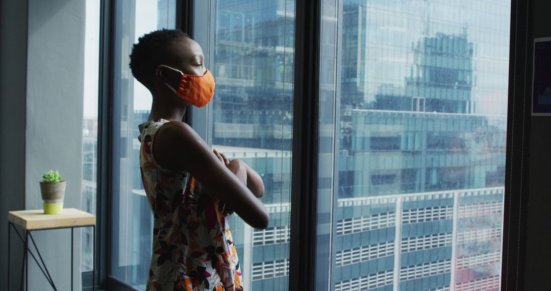 Woman Wearing Face Mask Looking Out of Window in Office - Free Images, Stock Photos and Pictures on Pikwizard.com