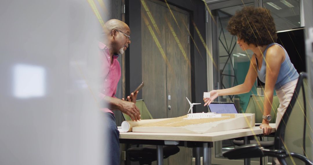 Designers Collaborating on Wind Turbine Project in Office Meeting