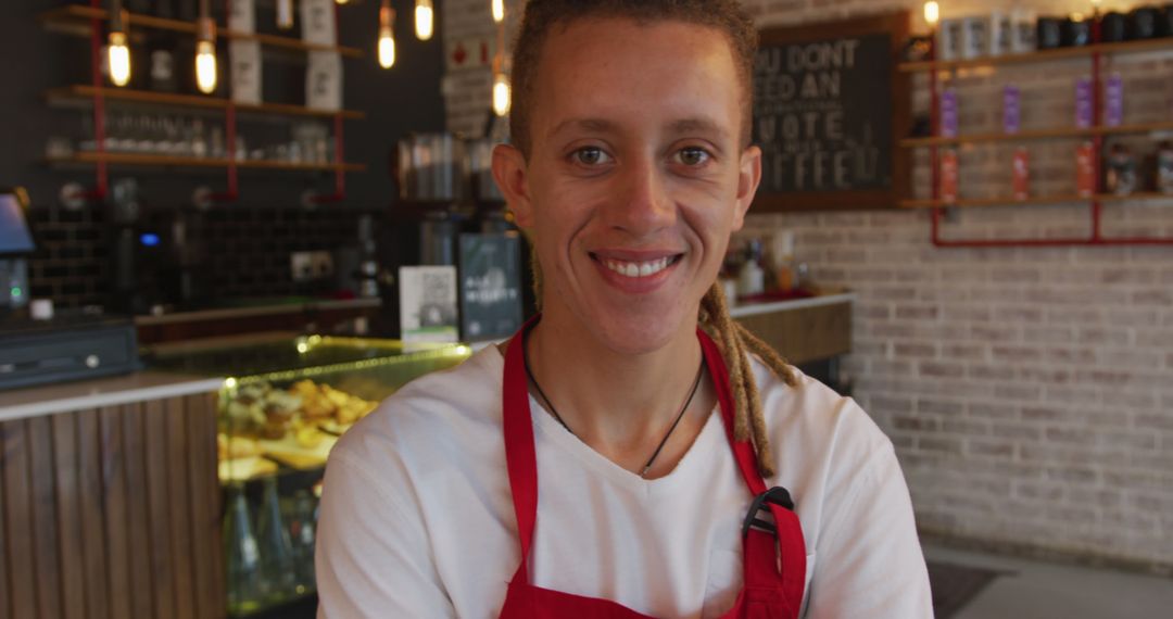 Friendly Barista with Red Apron Smiling in Trendy Coffee Shop - Free Images, Stock Photos and Pictures on Pikwizard.com