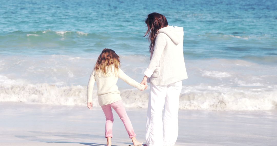 Mother and Daughter Holding Hands on Beach - Free Images, Stock Photos and Pictures on Pikwizard.com