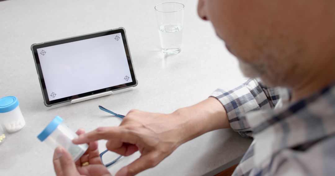 Man Logging Medication on Tablet in Home - Free Images, Stock Photos and Pictures on Pikwizard.com