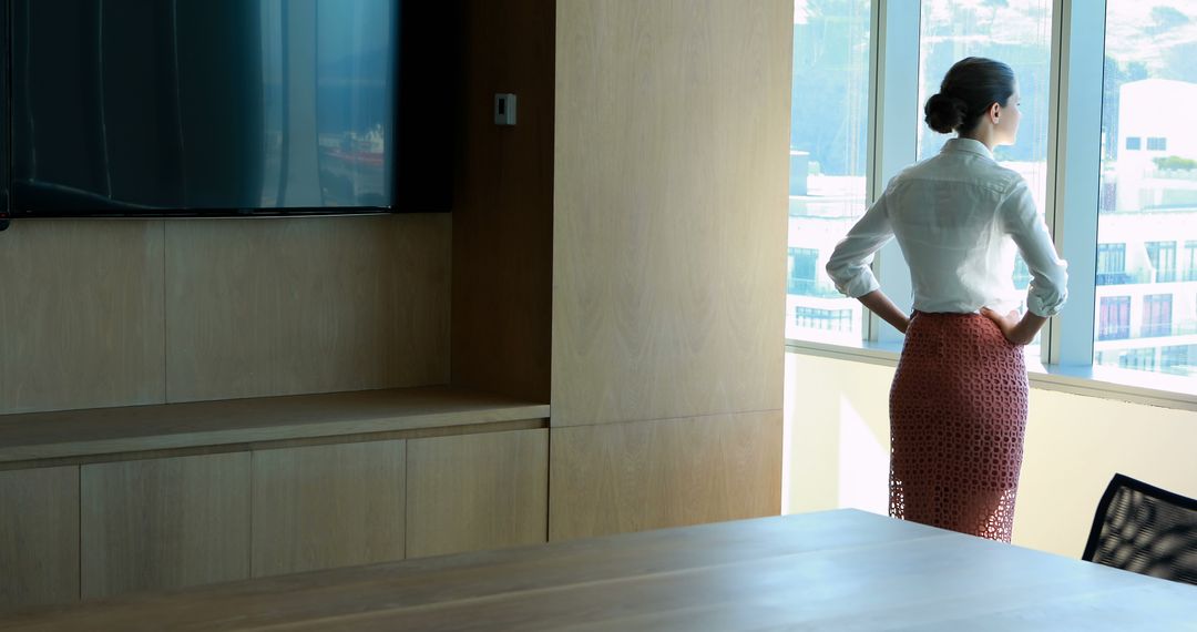 Businesswoman Standing in Modern Office Looking Out Window - Free Images, Stock Photos and Pictures on Pikwizard.com