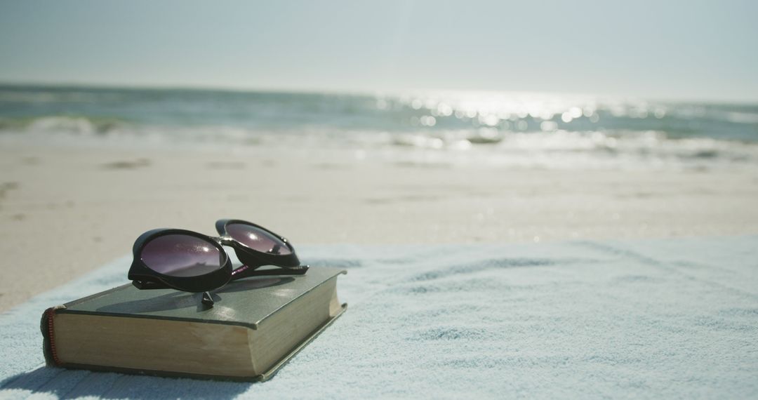 Sunglasses on Book at Beach, Relaxing Summer Vacation Scene - Free Images, Stock Photos and Pictures on Pikwizard.com