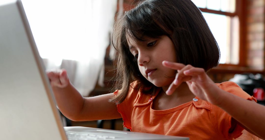 Young Girl Learning on Laptop at Home with Orange Top - Free Images, Stock Photos and Pictures on Pikwizard.com