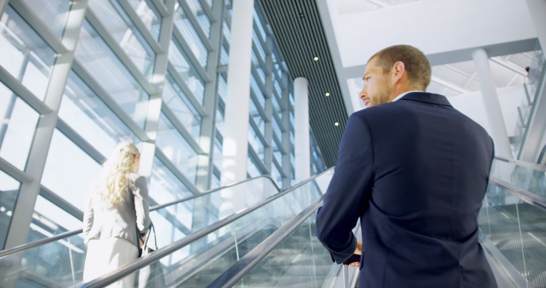 Business Professionals Ascending Modern Office Building Escalator - Free Images, Stock Photos and Pictures on Pikwizard.com