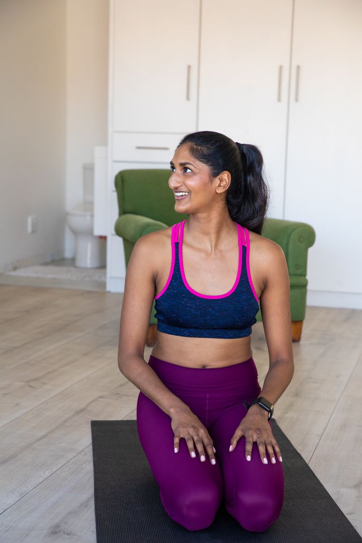 Woman Smiling Kneeling on Exercise Mat at Home