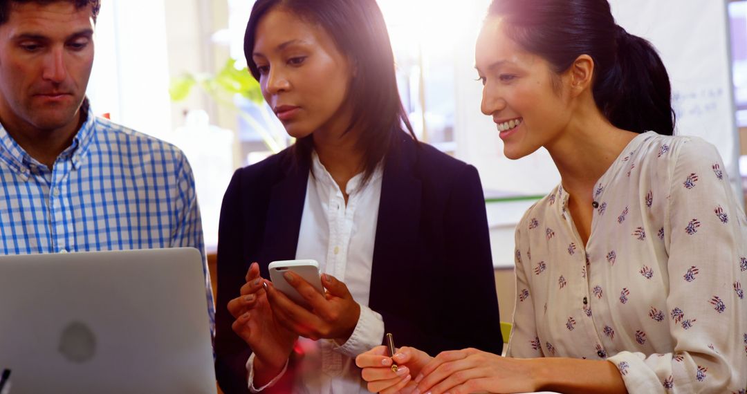 Diverse Business Team Collaborating on Laptop in Office