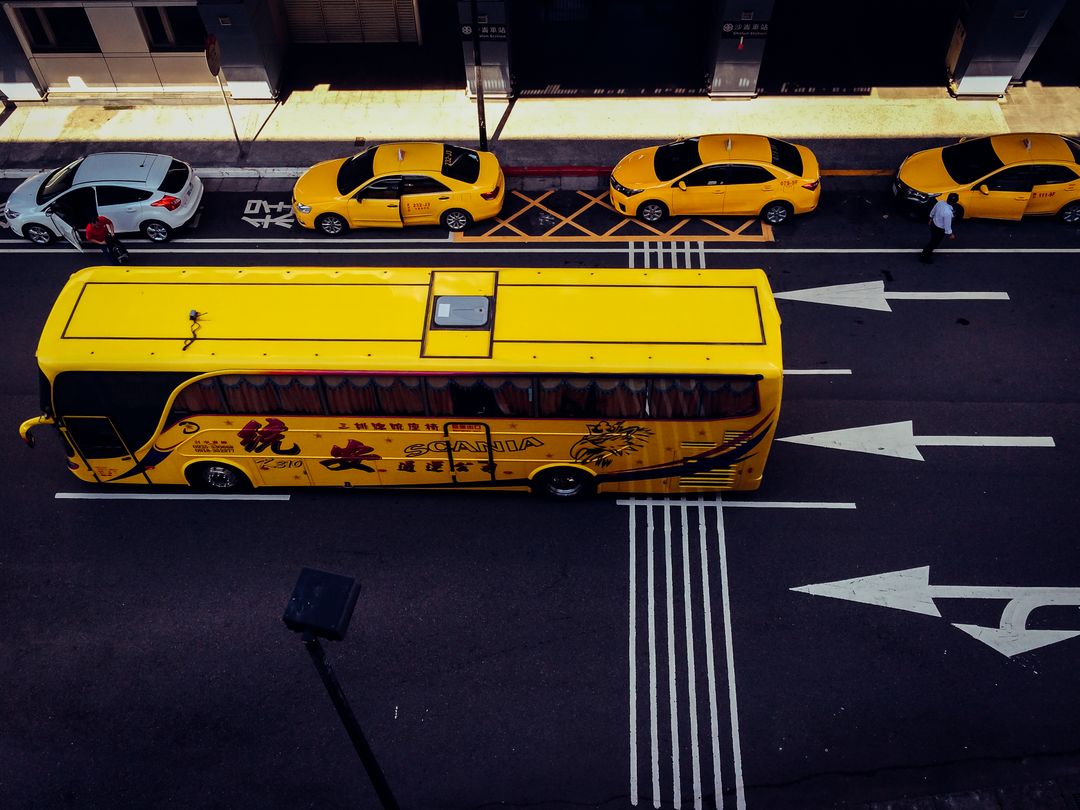 Yellow Bus and Taxis on Urban Street with Dark Shadows - Free Images, Stock Photos and Pictures on Pikwizard.com