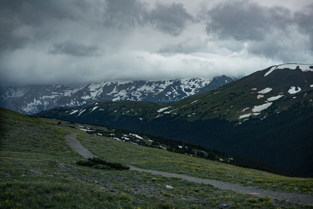 Majestic Mountain Range Under Stormy Skies with Snow Patches - Free Images, Stock Photos and Pictures on Pikwizard.com