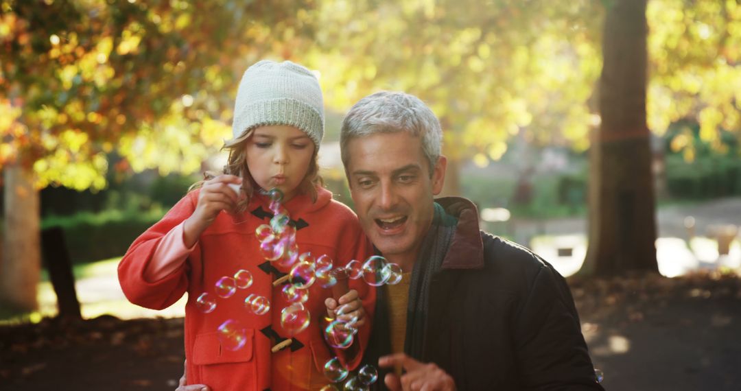 Father and Daughter Blowing Bubbles in Autumn Park - Free Images, Stock Photos and Pictures on Pikwizard.com