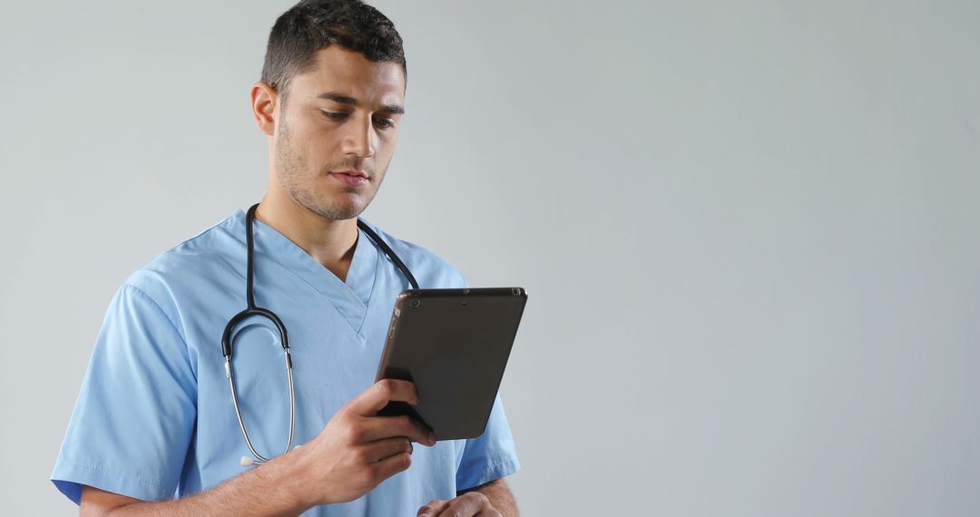 Male Doctor Using Digital Tablet for Patient Records in Medical Office - Free Images, Stock Photos and Pictures on Pikwizard.com