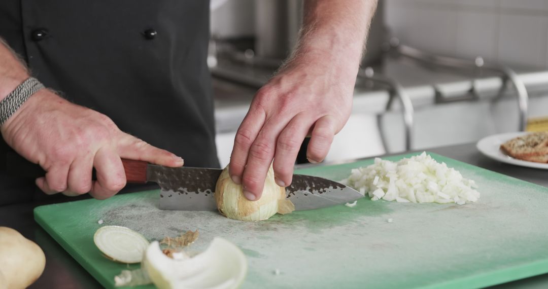 Chef chopping onion on green cutting board in kitchen - Free Images, Stock Photos and Pictures on Pikwizard.com