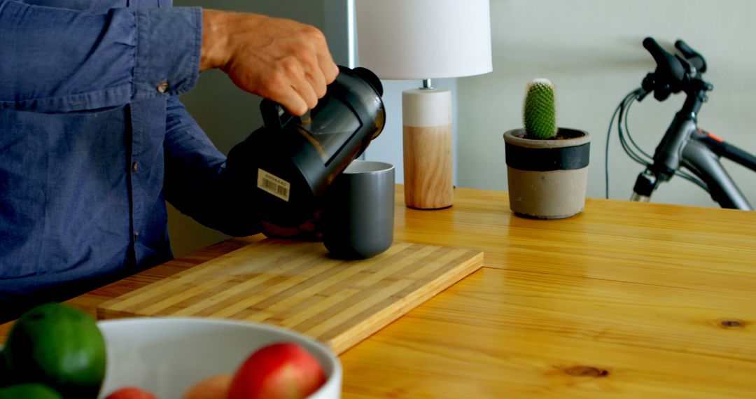 Man Pouring Coffee from French Press on Wooden Counter in Modern Kitchen - Free Images, Stock Photos and Pictures on Pikwizard.com