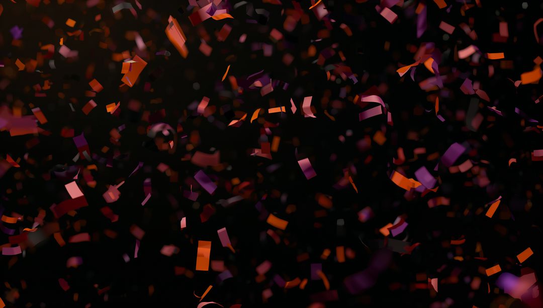 Colorful Red and Purple Confetti Floating on Black Background