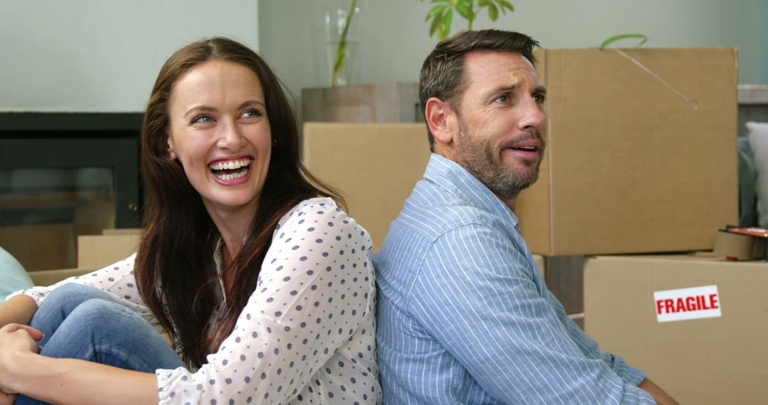 Happy Couple Relaxing Amidst Moving Boxes in New Home