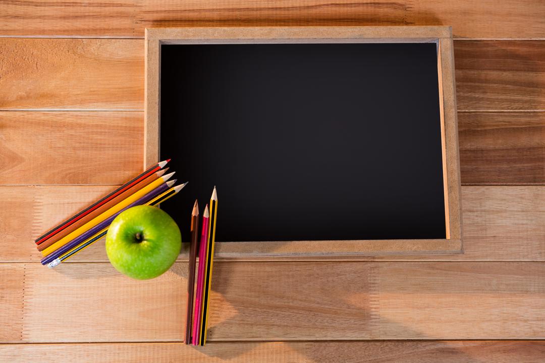 Chalkboard with Colored Pencils and Green Apple on Wooden Table - Free Images, Stock Photos and Pictures on Pikwizard.com