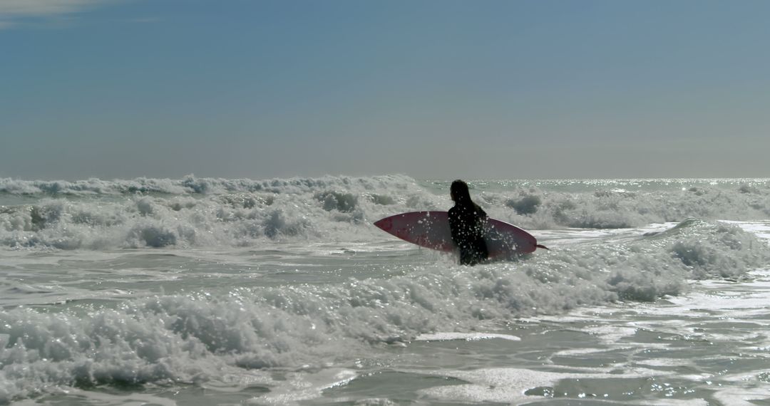 Surfer with board jumping waves in the ocean - Free Images, Stock Photos and Pictures on Pikwizard.com