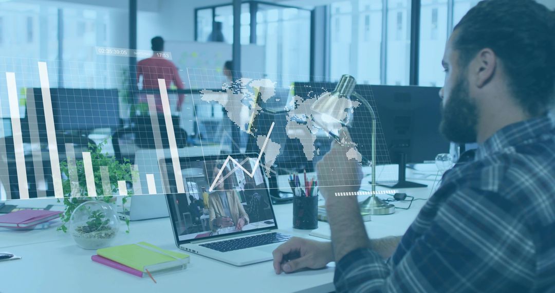 Concentrated Man in Modern Office Using Laptop for Analysis