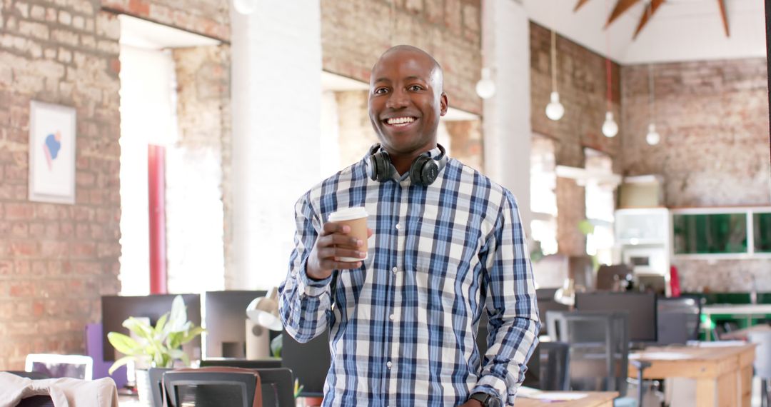 Smiling Man Holding Coffee Cup in Modern Office - Free Images, Stock Photos and Pictures on Pikwizard.com