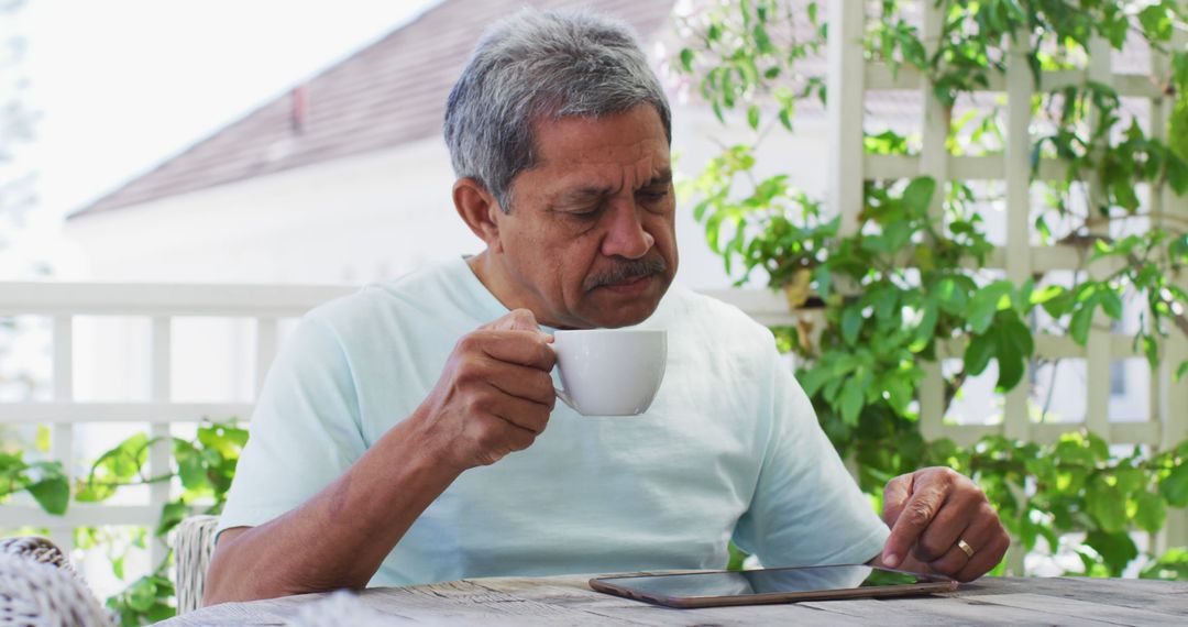 Senior Man Drinking Coffee and Using Tablet at Patio - Free Images, Stock Photos and Pictures on Pikwizard.com