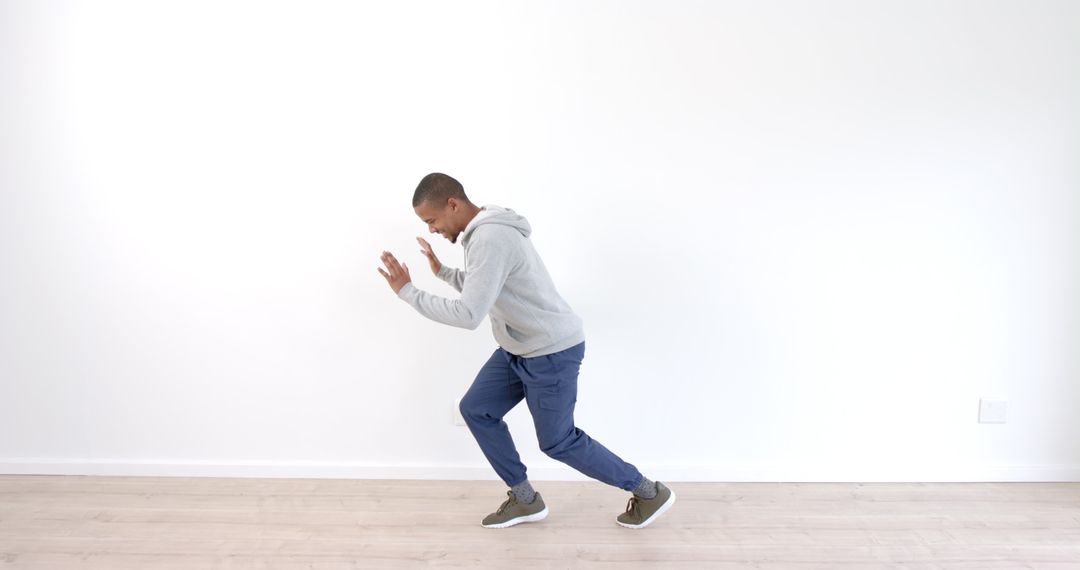 Man Practicing Energetic Dance Moves in Minimalist Space
