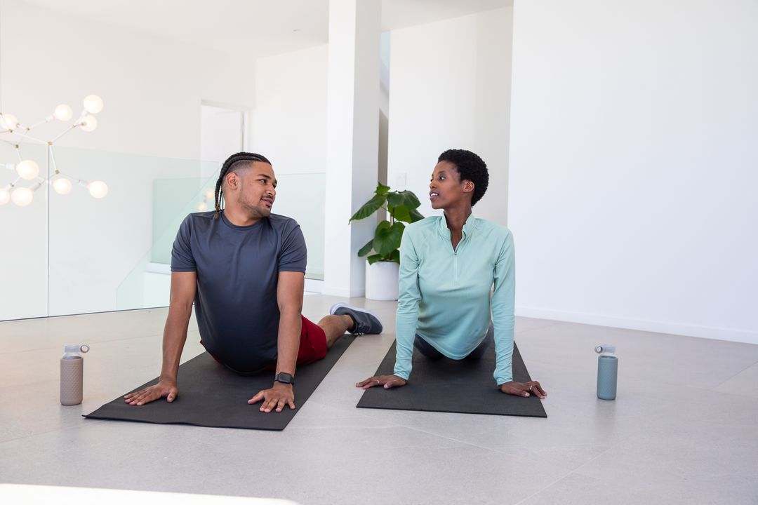 Diverse Friends Practicing Yoga in Modern Exercise Space