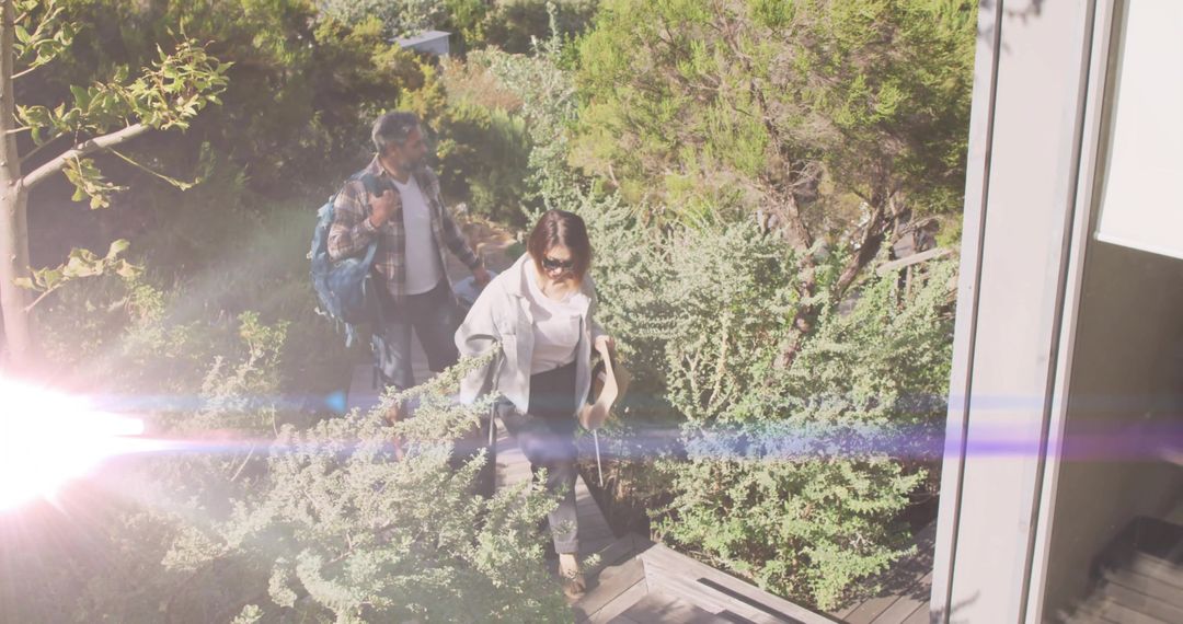 Couple Ascending Pathway with Mountaineering Gear on Bright Day
