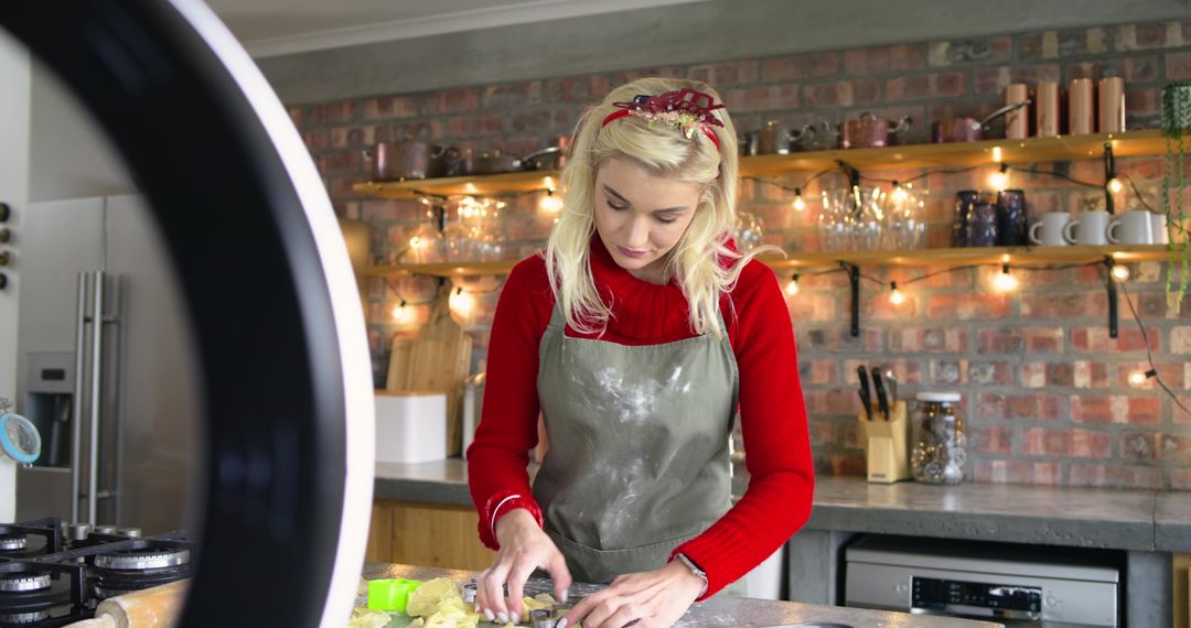 Home Baker Kneading Dough for Holiday Cookies in Rustic Kitchen with Warm String Lights