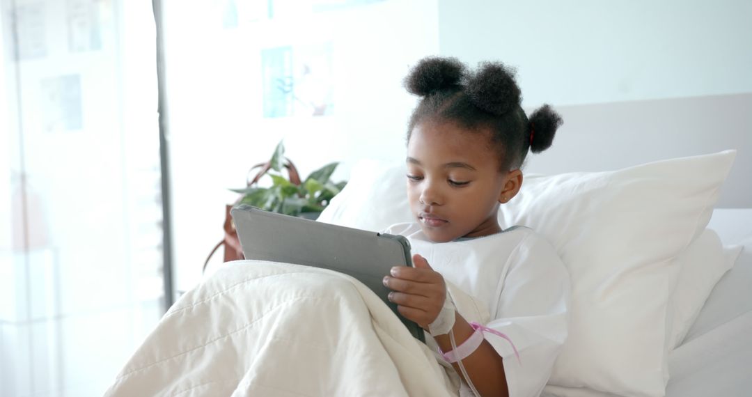 African American girl using digital tablet in hospital bed - Free Images, Stock Photos and Pictures on Pikwizard.com