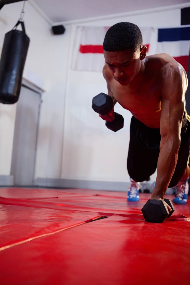 Strong Athlete Doing Dumbbell Push-Up in Boxing Gym for Cardio Fitness