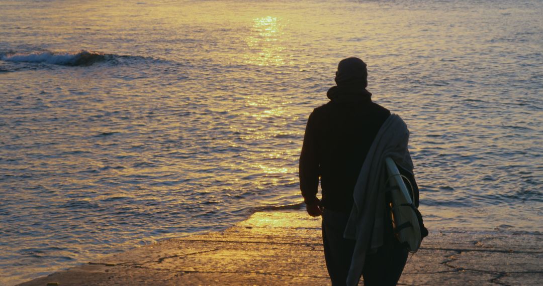 Silhouette of Man Carrying Surfboard during Sunset by Ocean Shore - Free Images, Stock Photos and Pictures on Pikwizard.com