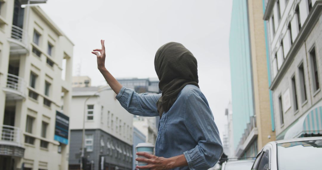 Woman Hailing Taxi on Urban Street while Holding Coffee Cup - Free Images, Stock Photos and Pictures on Pikwizard.com