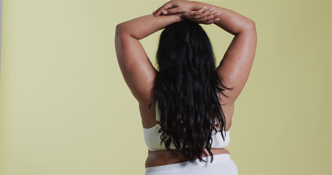 Confident Woman in White Lingerie Standing Against Yellow Background