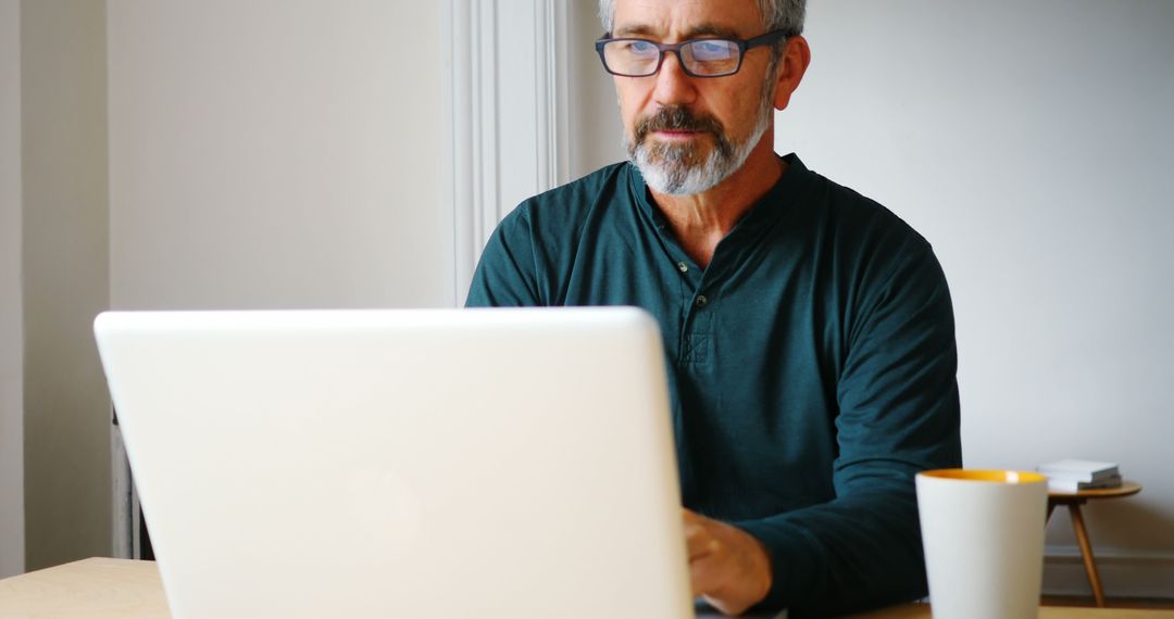 Mature Man Working on Laptop in Home Office Setting - Free Images, Stock Photos and Pictures on Pikwizard.com