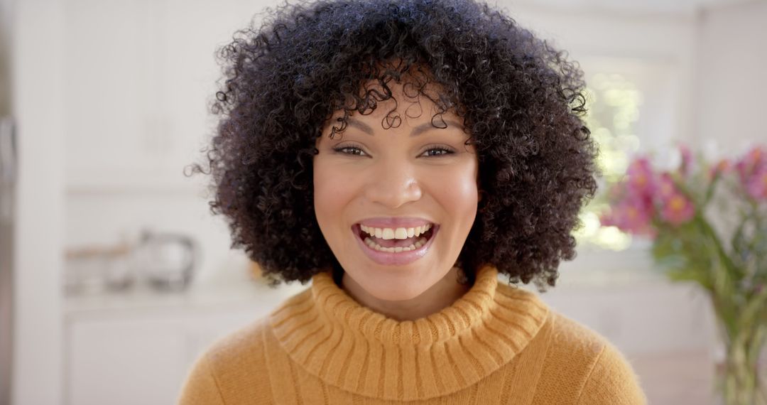 Smiling Woman with Curly Hair in Bright Kitchen - Free Images, Stock Photos and Pictures on Pikwizard.com