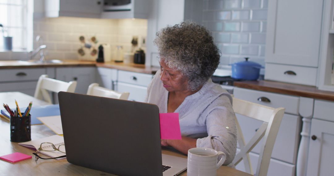 Senior Woman Using Laptop in Bright Modern Kitchen Interior - Free Images, Stock Photos and Pictures on Pikwizard.com