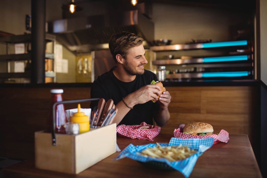 Man Enjoying Burger and Fries in Cozy Diner Setting