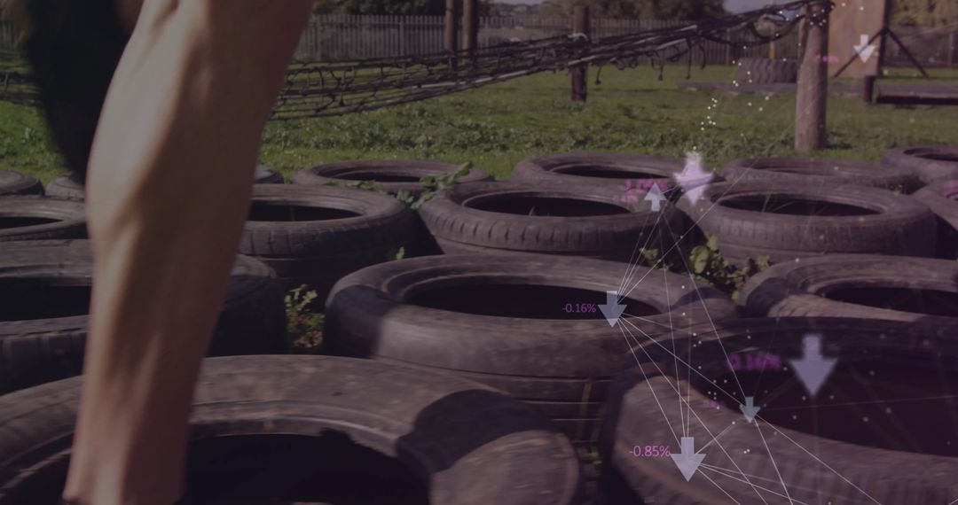 Athlete Navigating Tire Obstacle with Digital Interface Outdoors