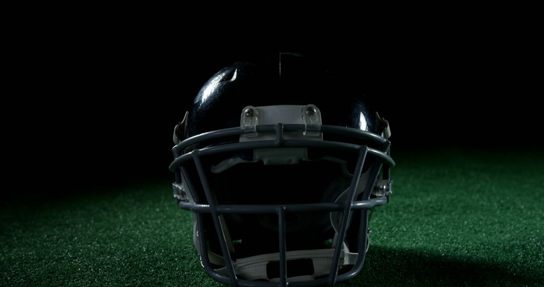 American Football Helmet on Green Turf Under Spotlights - Free Images, Stock Photos and Pictures on Pikwizard.com