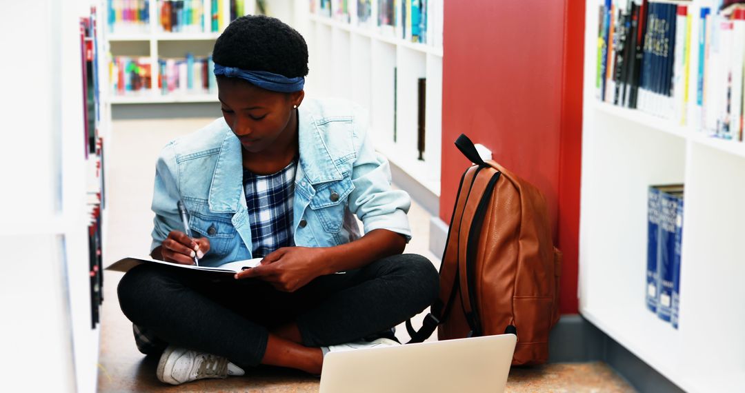 Focused Student Studying in Library with Technology