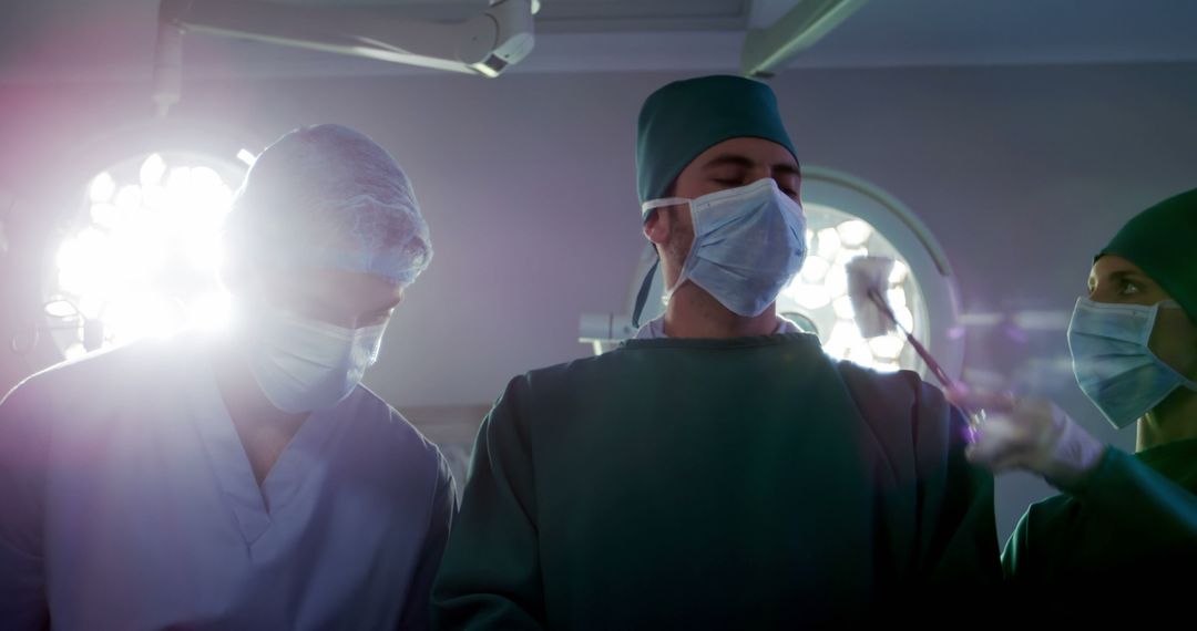 A multicultural team of surgeons performs a critical surgery in a well-lit operating room. - Free Images, Stock Photos and Pictures on Pikwizard.com