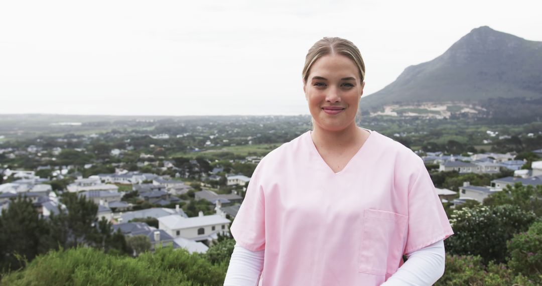 Smiling Nurse Standing Outdoors with Mountain and Town View - Free Images, Stock Photos and Pictures on Pikwizard.com