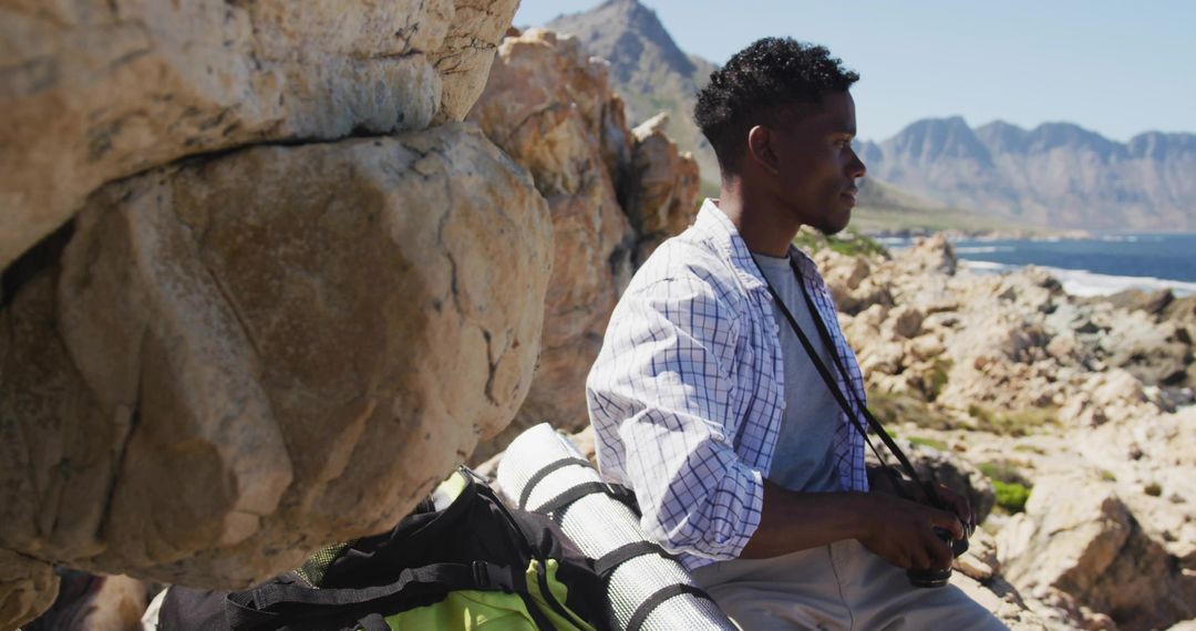 Explorer with camera on rocky coastal adventure