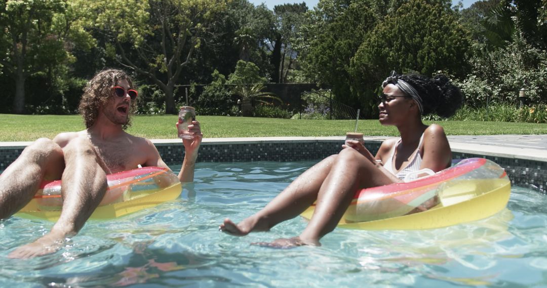 Couple Relaxing on Floaties in Pool Enjoying Leisure Time