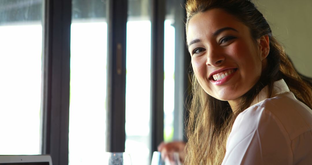 Smiling Woman by Sunny Window in Cafe - Free Images, Stock Photos and Pictures on Pikwizard.com