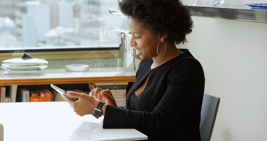African American Woman Smiling While Using Tablet at Home