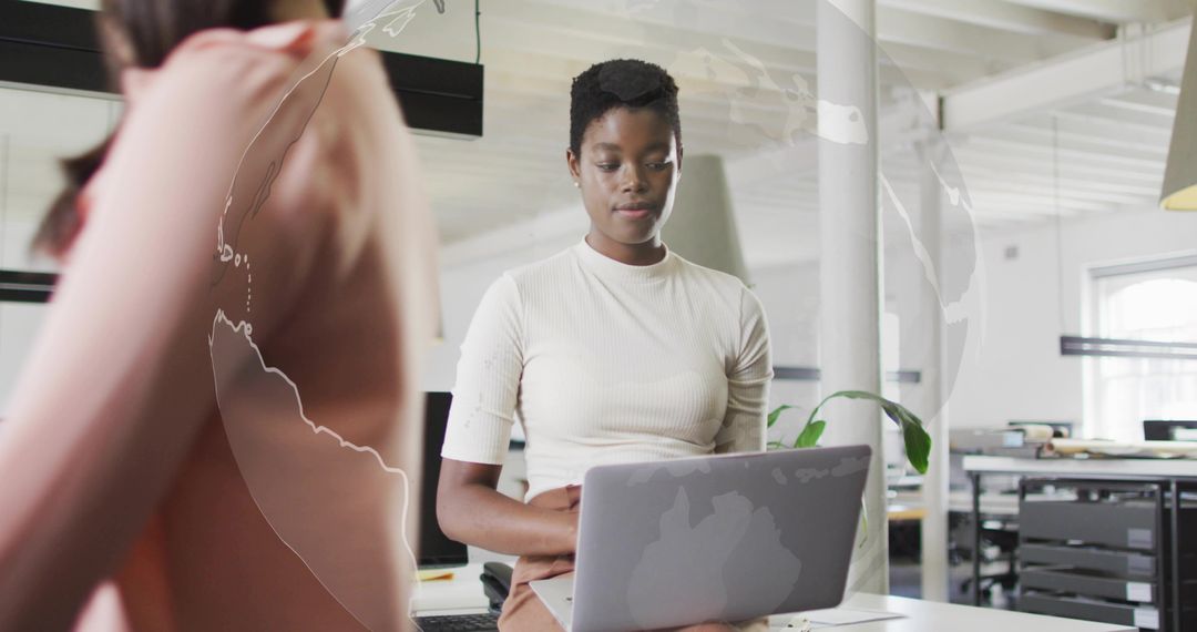 Focused Professional Typing on Laptop in Modern Office Environment
