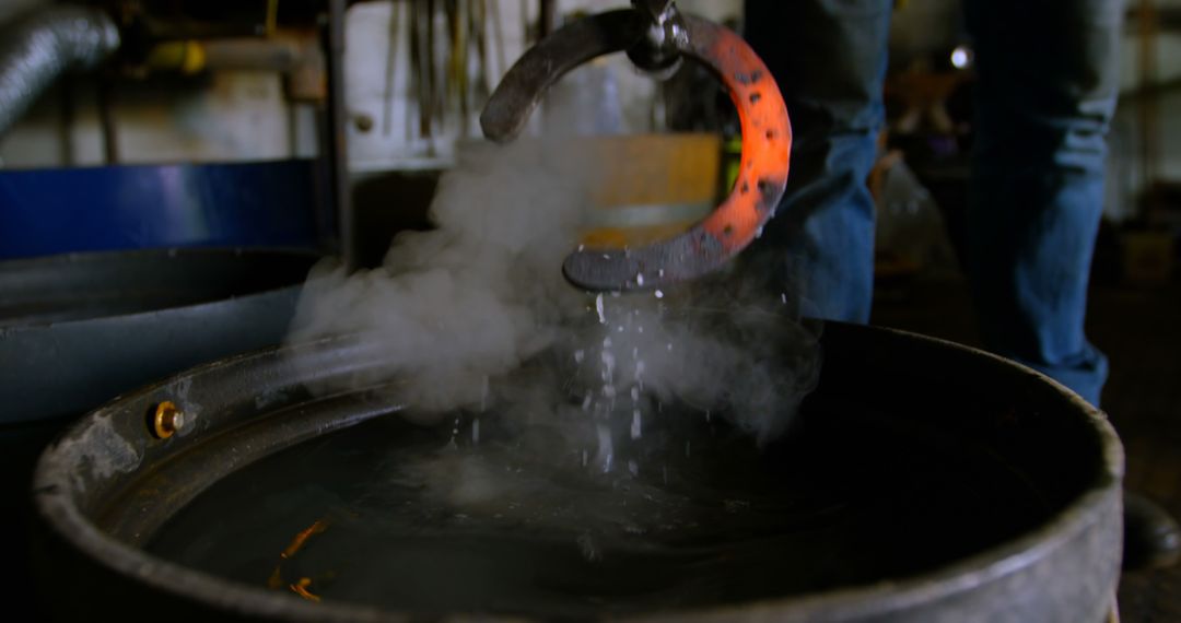 Blacksmith Cooling Hot Metal in Water with Steam Rising - Free Images, Stock Photos and Pictures on Pikwizard.com